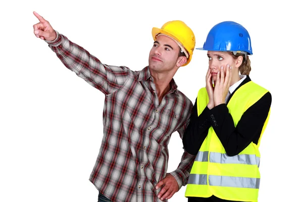 Женщина-архитектор выглядит потрясенной и мужчина-строитель — стоковое фото