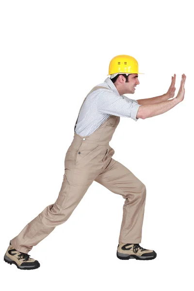 Foreman empurrando forte contra uma parede — Fotografia de Stock