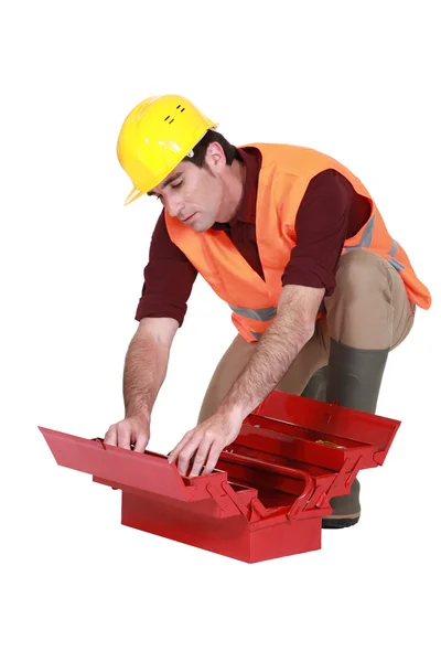 Trabalhador procurando em uma caixa de ferramentas — Fotografia de Stock