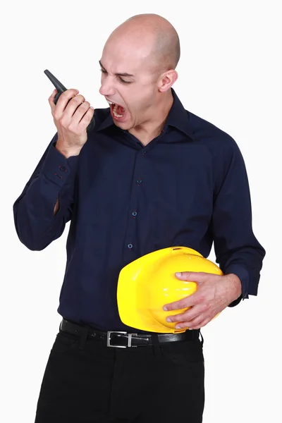 Engineer screaming into a walkie-talkie — Stock Photo, Image