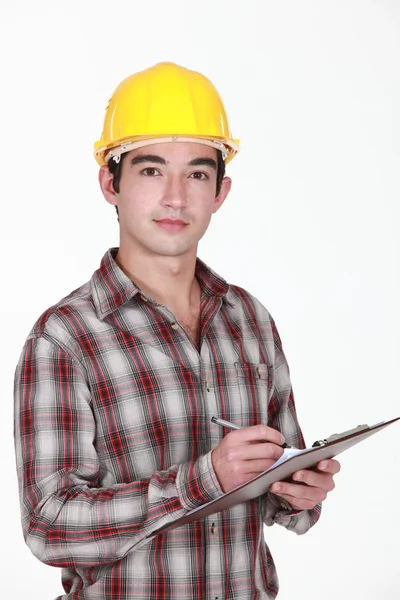 Man in a hardhat with a clipboard — Stock Photo, Image