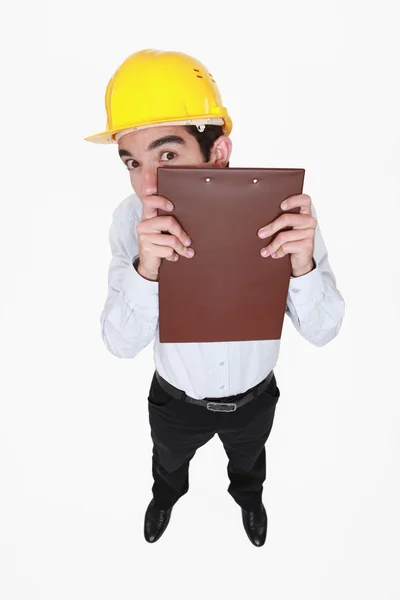 Man hiding behind a clipboard — Stock Photo, Image