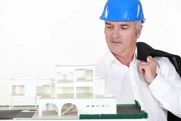 Reifer Architekt posiert in der Nähe eines Modells — Stockfoto