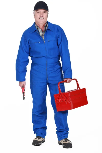 Tradesman holding a tool and his toolbox — Stock Photo, Image