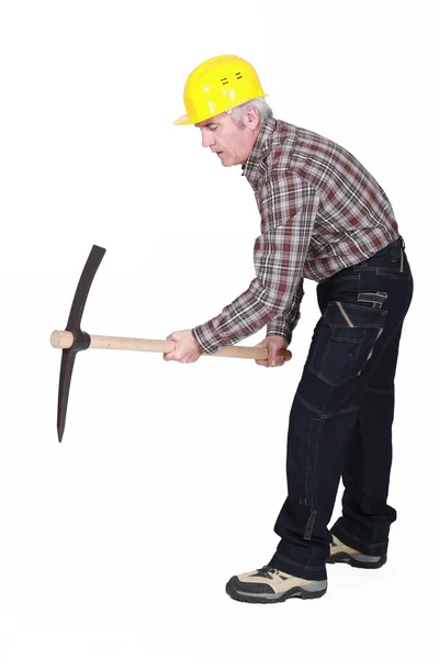 Un operaio edile maturo che usa un piccone . — Foto Stock