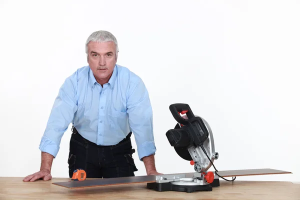Grey-haired man with circular saw — Stock Photo, Image