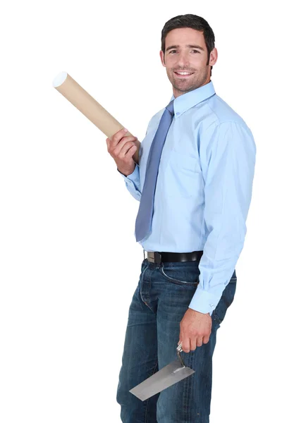 Engineer holding a rolled-up plan and a trowel — Stock Photo, Image
