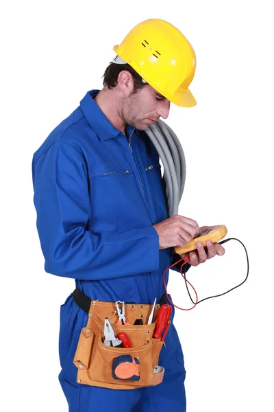 Eletricista segurando uma ferramenta de medição — Fotografia de Stock