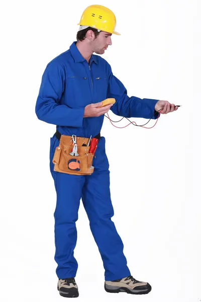 Eletricista com um multímetro — Fotografia de Stock