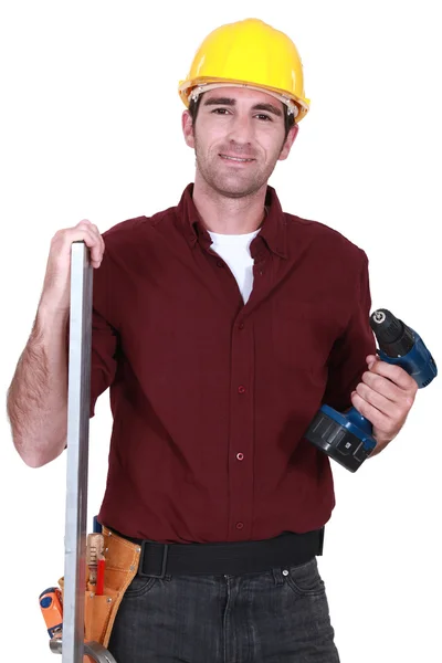 Builder posing with drill and plank — Stock Photo, Image