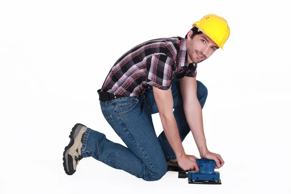 Tradesman usando uma lixadeira — Fotografia de Stock