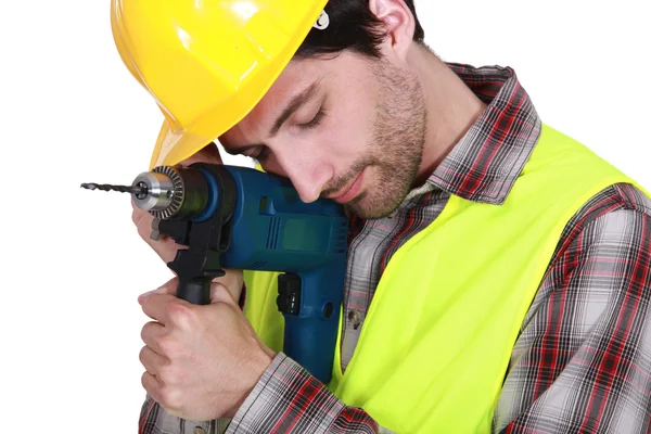 Handwerker stützt seinen Kopf auf eine Bohrmaschine — Stockfoto