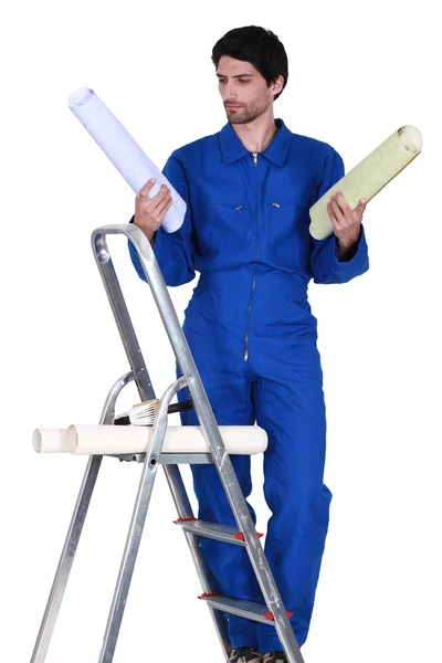 Man stond op stap-ladder kiezen welke kleur achtergrond te gebruiken — Stockfoto