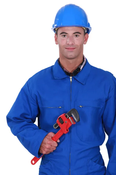 Worker holding red wrench — Stockfoto