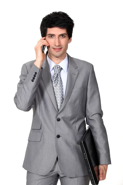 Mladý podnikatel drží aktovku a mluví na mobil — Stock fotografie