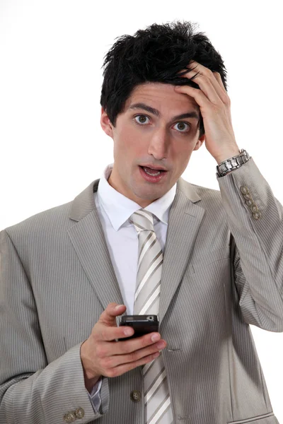 Businessman in shock at his phone — Stock Photo, Image