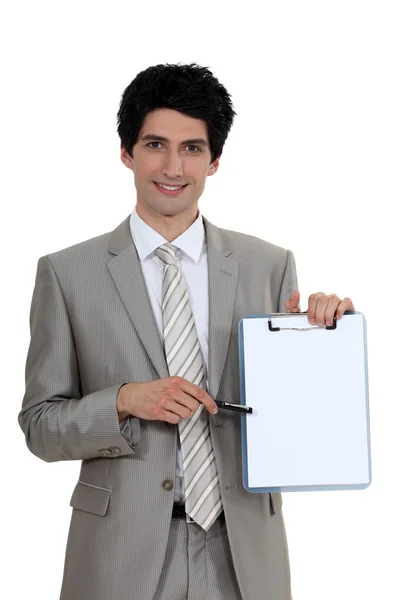 Empresario apuntando a un portapapeles en blanco —  Fotos de Stock