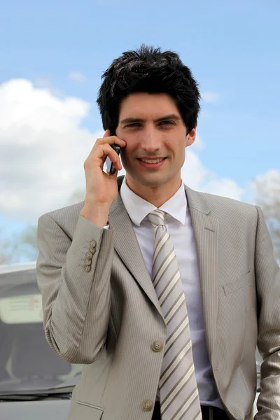 Jonge zakenman maken telefoontje van langs de weg — Stockfoto