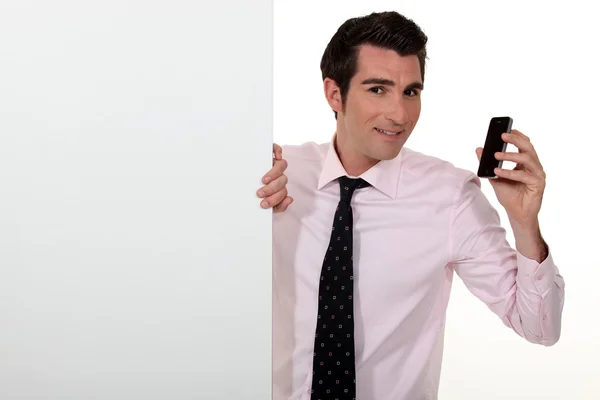 Salesman with a cellphone and blank board — Stock Photo, Image