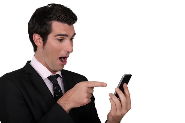 Überraschter Mann zeigt auf sein Handy — Stockfoto