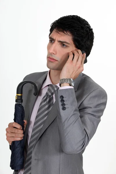 Businessman talking on his cell and looking serious — Stock Photo, Image