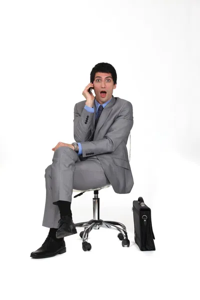 Retrato de homem de negócios sentado na cadeira giratória olhando espantado — Fotografia de Stock