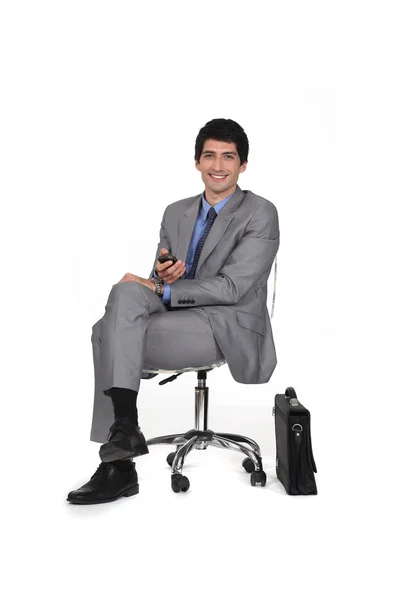 Бізнесмен сидить на стільці і дивиться телевізор — стокове фото