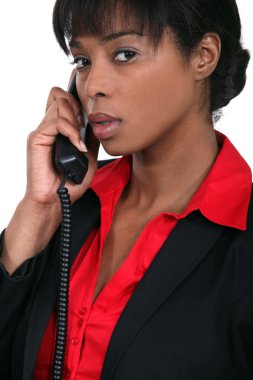 Businesswoman using a landline clipart