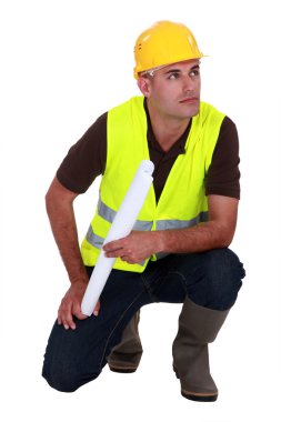 Engineer in a reflective vest with plans clipart