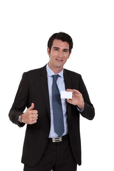 Young businessman with business card giving the thumbs-up — Stock Photo, Image