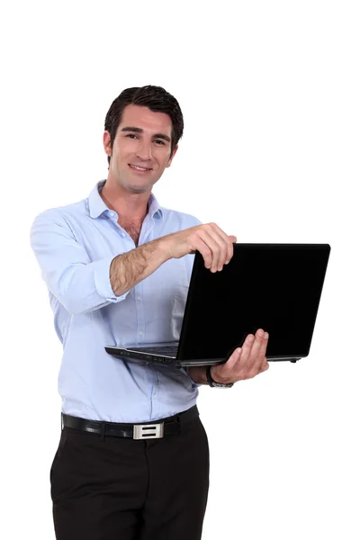 Um homem de negócios de pé com seu laptop . — Fotografia de Stock