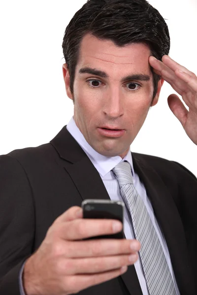 Empresário atordoado lendo uma mensagem de texto — Fotografia de Stock