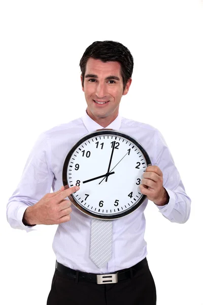 Happy businessman pointing at clock — Stock Photo, Image