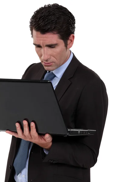 Biznesmen stałego i pisania na swoim laptopie. — Zdjęcie stockowe