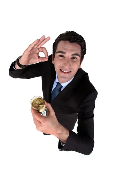 Uomo d'affari che beve un bicchiere di vino e fa il gesto a-ok — Foto Stock