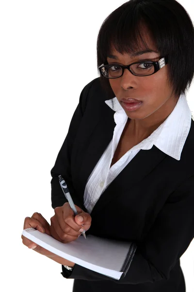 Een Afro-Amerikaanse zakenvrouw in het maken van notities. — Stockfoto