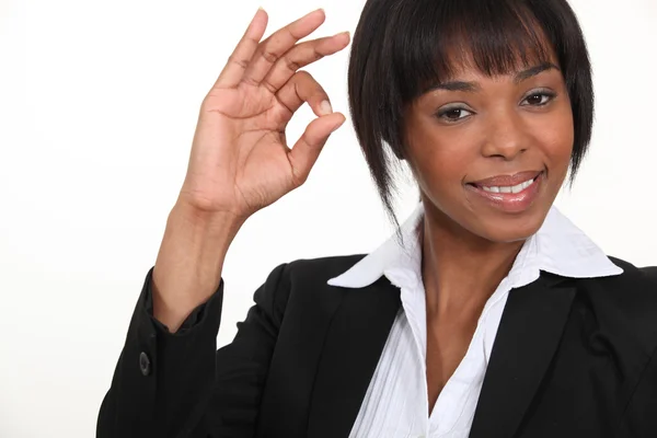 Een Afro-Amerikaanse zakenvrouw gebaren een ok teken. — Stockfoto