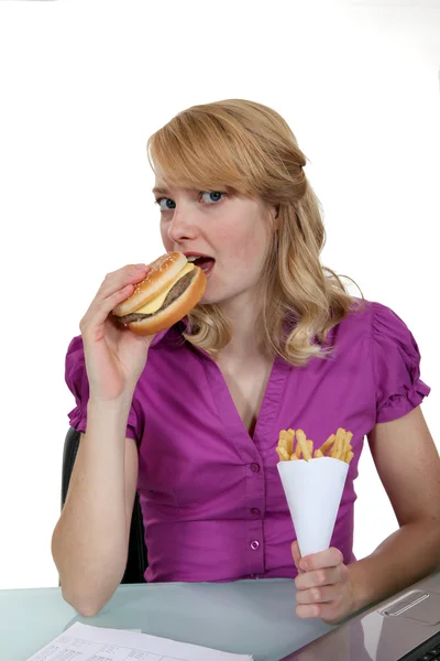 Donna mangiare hamburger e patatine fritte — Foto Stock