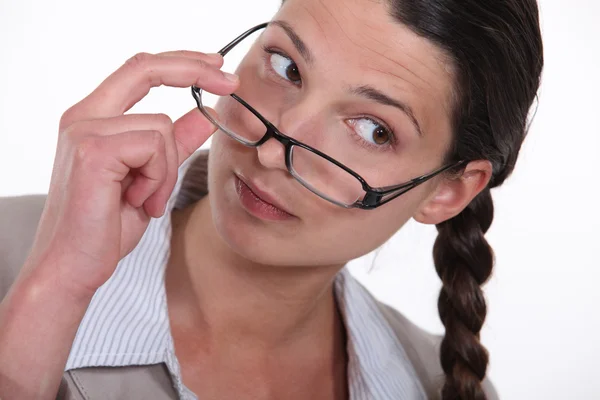 En affärskvinna som lyfter hennes glasögon. — Stockfoto