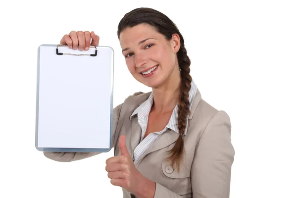 Woman giving the thumbs up to a blank clipboard — Stock Photo, Image