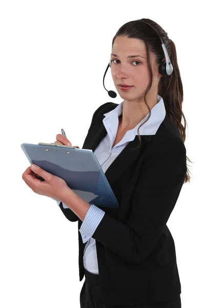 Brunette callcenter werknemer schrijven op clip-bord — Stockfoto