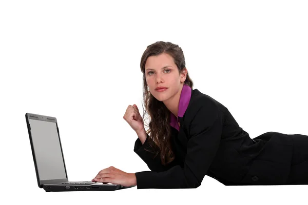 Mujer de negocios acostada en el suelo con su portátil — Foto de Stock