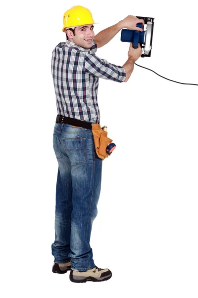 Τεχνίτης κρατώντας ένα ηλεκτρικό πριόνι — Φωτογραφία Αρχείου