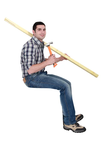 Joiner sentou-se com prancha de madeira e martelo — Fotografia de Stock