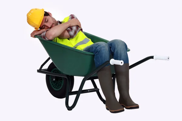 Ein Straßenarbeiter schläft in einer Schubkarre. — Stockfoto