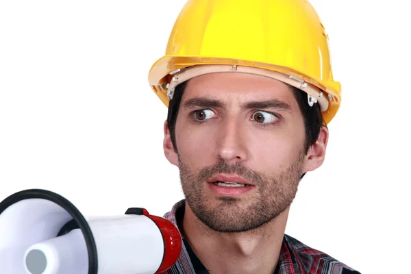 A disturbed tradesman holding a megaphone — Stock Photo, Image