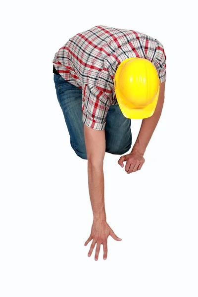 Tradesperson reaching to pick up a fallen object — Stock Photo, Image