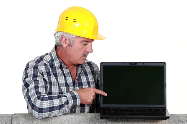 Торговець вказує на свій новий ноутбук — стокове фото