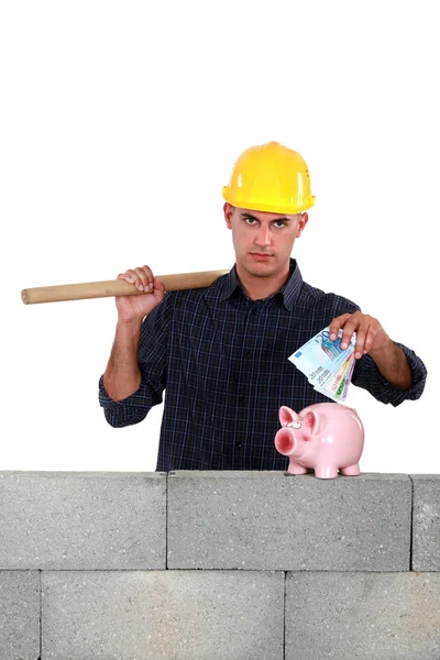 Builder holding sledge-hammer and lots of banknotes — Stock Photo, Image
