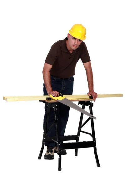 Um carpinteiro com uma serra manual . — Fotografia de Stock